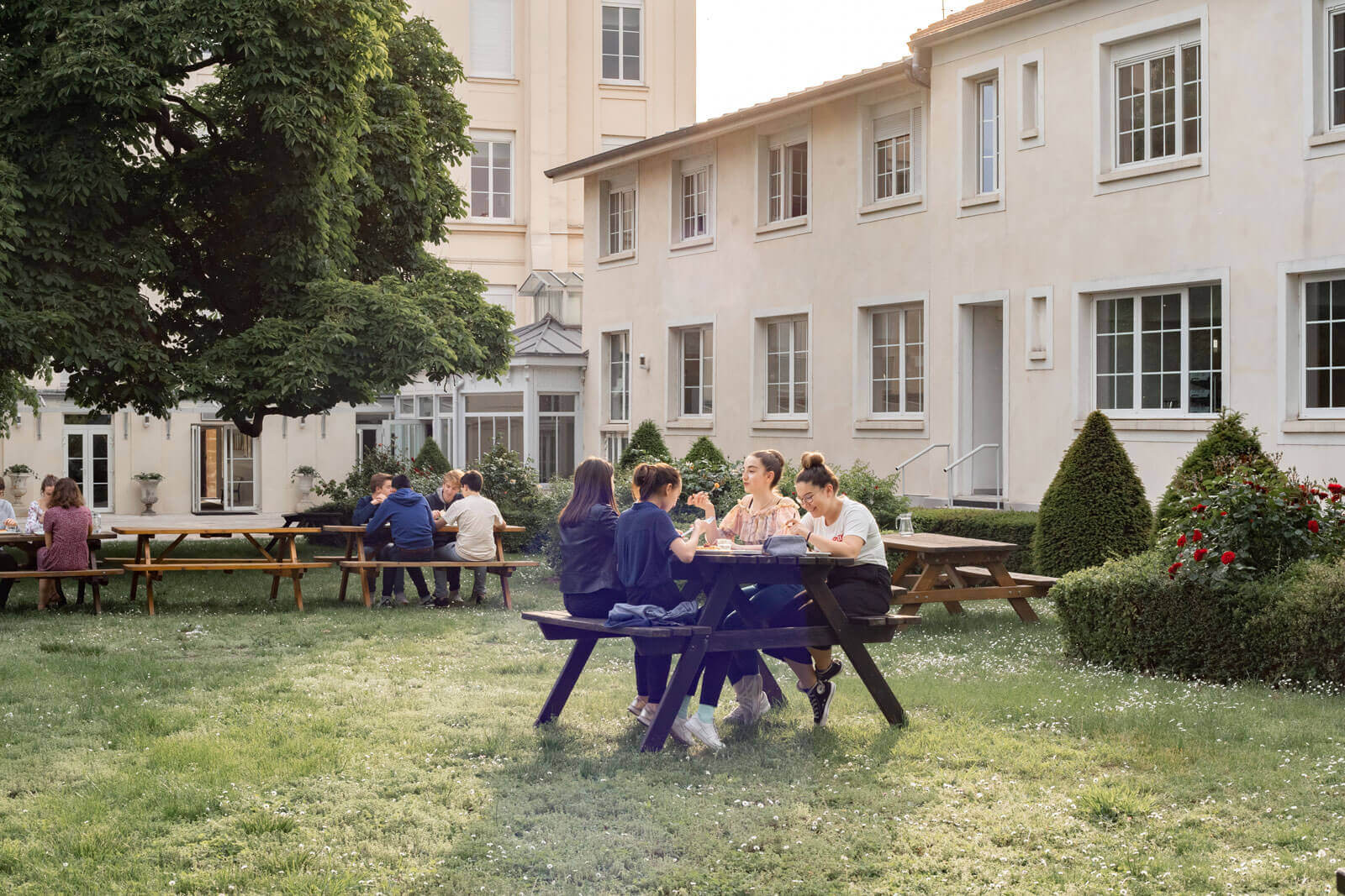 Etudiants en train de manger à l'extérieur, dans le jardin verdoyant du Foyer étudiant Les Enfants des Arts, près de Paris